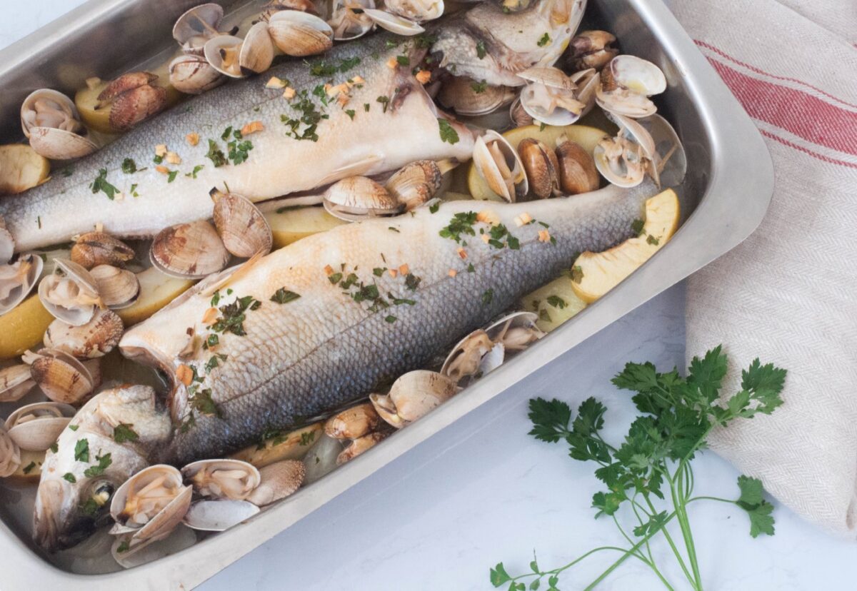 Lubina al horno con patatas, manzana y almejas