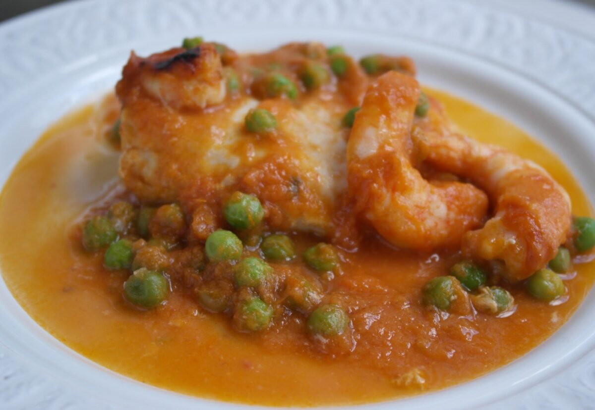 Merluza al horno con langostinos en salsa de tomate. Receta de pescado paso a paso