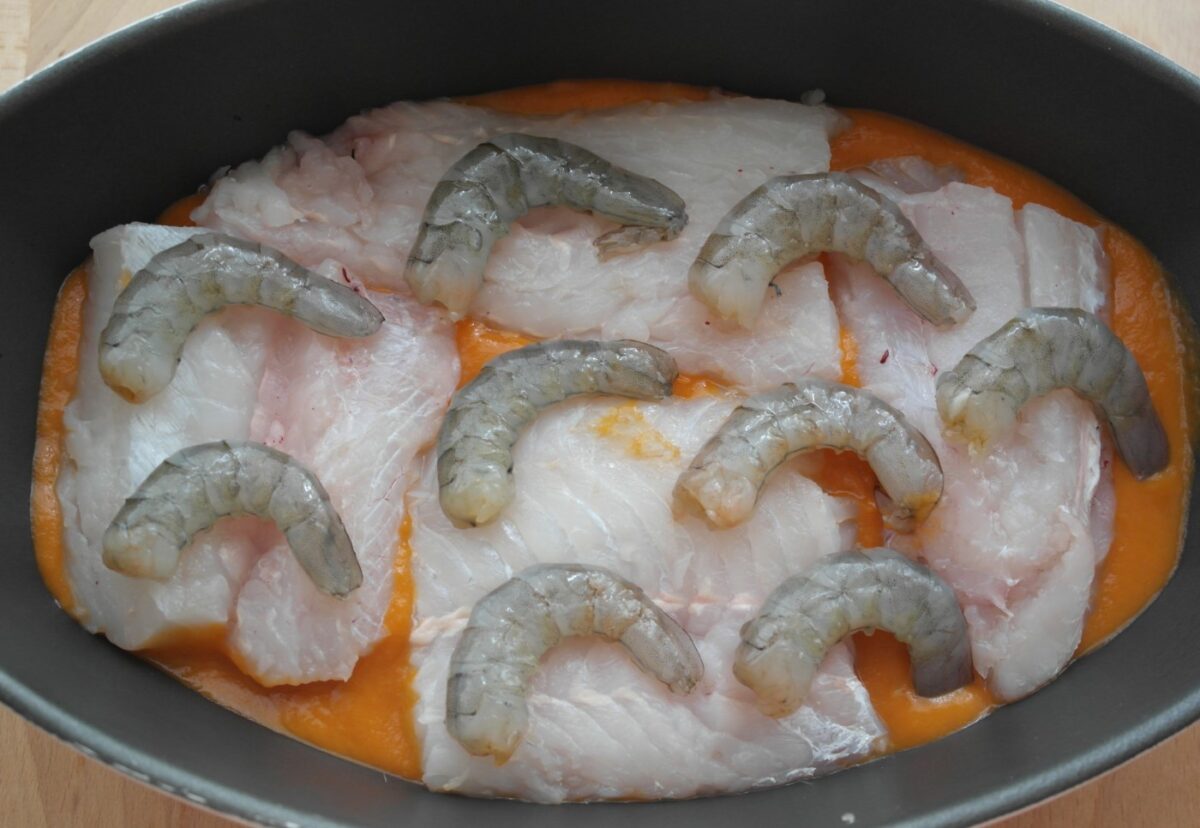 Merluza al horno con langostinos en salsa de tomate. Receta de pescado paso a paso