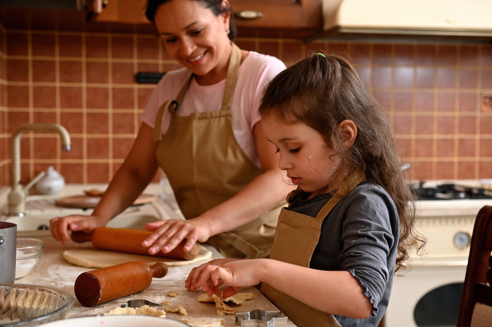 Niña colocando la masa de las tartaletas en moldes
