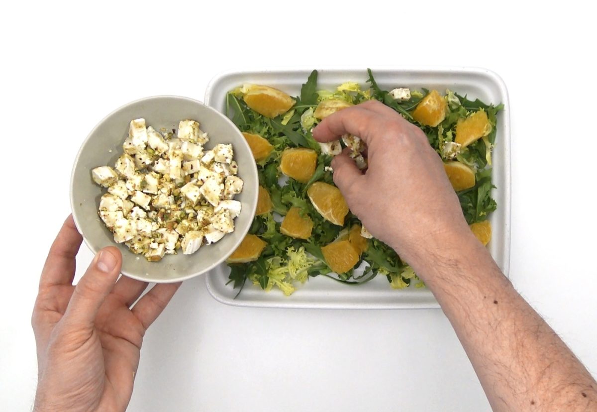 Ensalada de rúcula y escarola con queso de cabra, pistachos y naranja