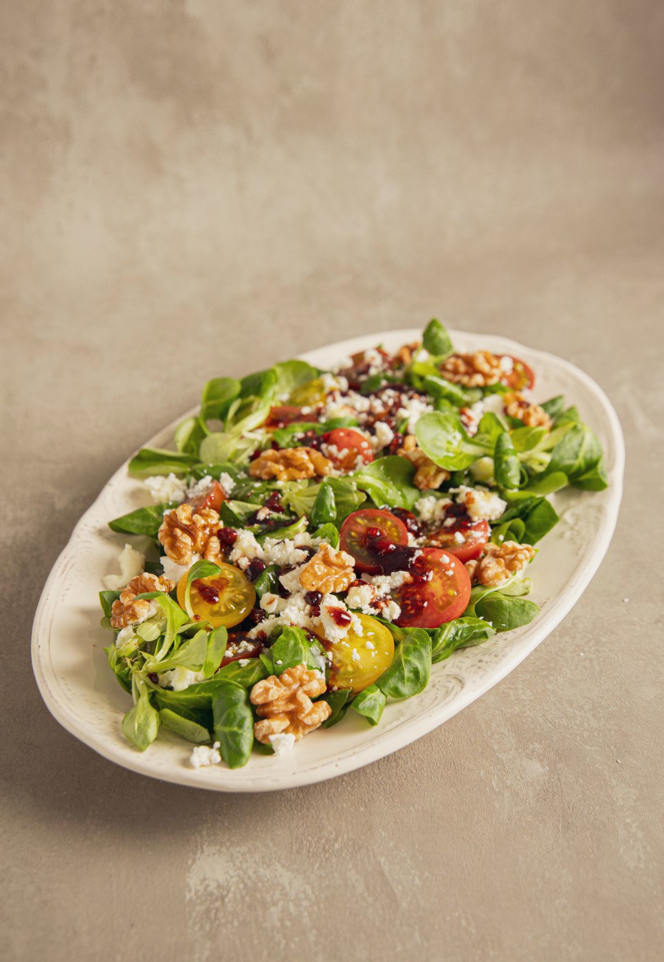 Ensalada de canónigos con queso de cabra, nueces y mermelada de frambuesa