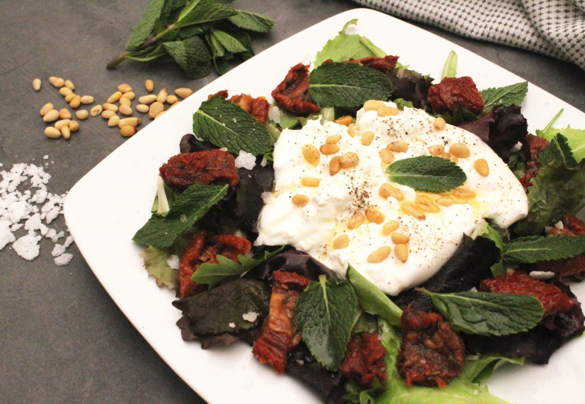 Ensalada de burrata con tomates secos, piñones y menta