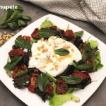 Ensalada de burrata con tomates secos, piñones y menta