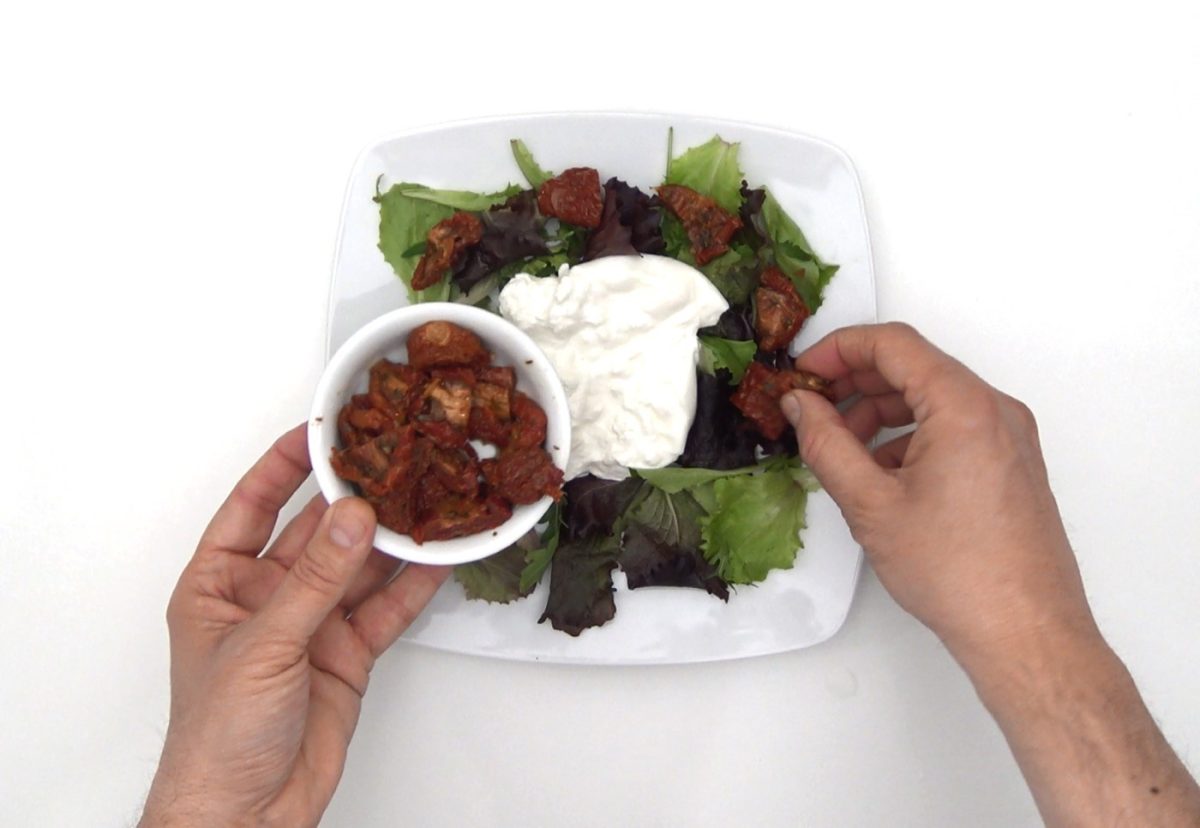 Ensalada de burrata con tomates secos, piñones y menta