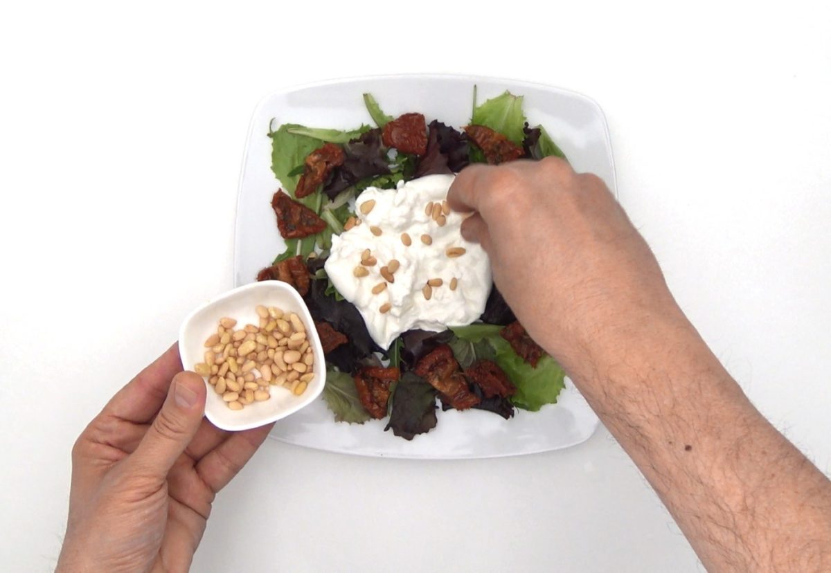 Ensalada de burrata con tomates secos, piñones y menta