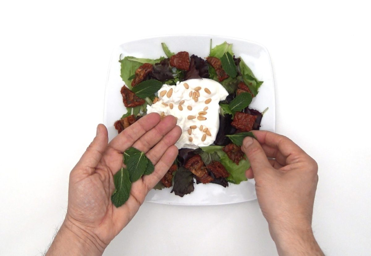 Ensalada de burrata con tomates secos, piñones y menta