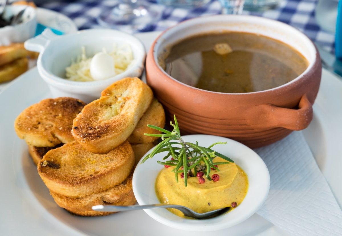 Sopa de pescado acompañada con salsa rouille y croutons de pan