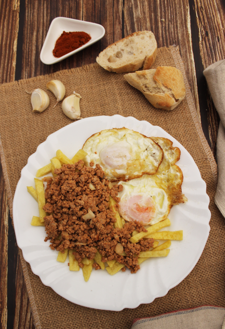 Picadillo de chorizo con patatas y huevo frito. Prepara pan porque te hará falta
