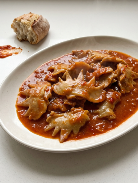 Crestas de gallo guisadas, una receta de casquería con salsa para mojar pan