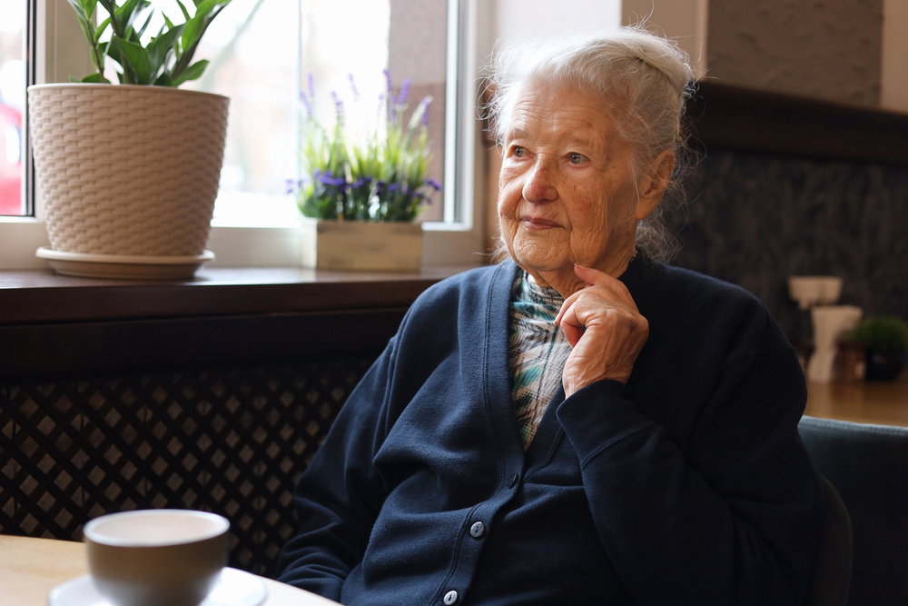 Mujer anciana sentada a la mesa
