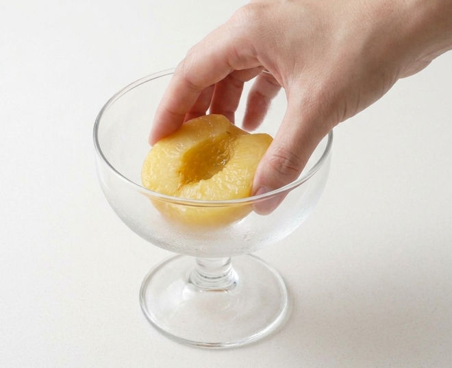 Peach Melba de Escoffier con montaje en copa, nata y frambuesas