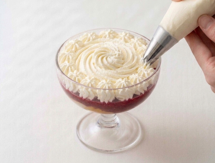 Peach Melba de Escoffier con montaje en copa, nata y frambuesas