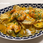 Huevos rotos con langostinos y caldo de marisco, con patatas finas y crujientes